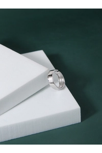 Close-up of polished silver wide band open ring showing mirror-like metallic finish