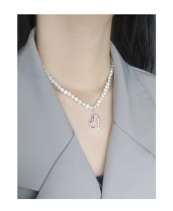 Detail of freshwater pearl necklace featuring a hollow silver heart pendant on a model