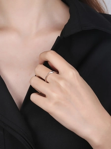 Polished silver Mobius ring detail on finger with a minimalist wave design and chic look