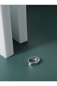 Macro shot of minimalist S925 sterling silver wide band ring with smooth metallic finish