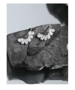 Detail of S925 silver stud earrings with baguette crystals on a black charcoal base