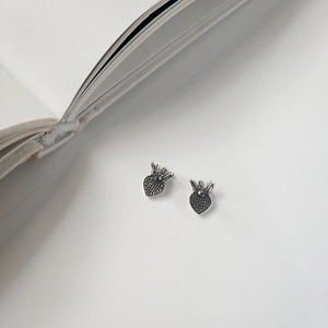 Macro shot of vintage S925 sterling silver heart crown studs with oxidized details