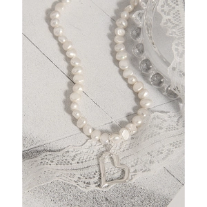 Elegant S925 silver necklace featuring natural freshwater pearls and a hollow heart pendant