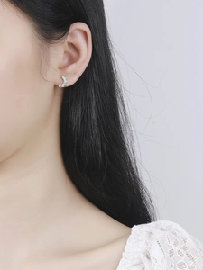 Detail of minimalist S925 sterling silver V-shape stud earrings with square zircons