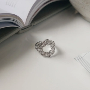Close-up of S925 sterling silver ring featuring irregular lava texture on white surface