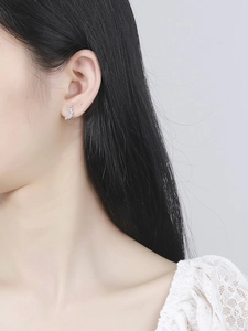 Macro shot of s925 silver stud earrings with baguette-cut crystals on a model's ear