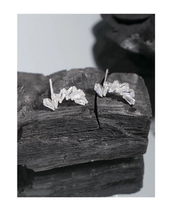 Detailed close-up of S925 sterling silver earrings with baguette-cut zircons on charcoal