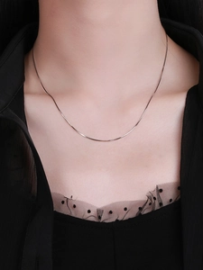 Close-up of a minimalist S925 sterling silver snake chain on a female model's neck