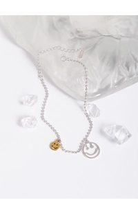 Détail macro d'une chaîne en argent sterling S925 avec pendentif sourire et étiquette