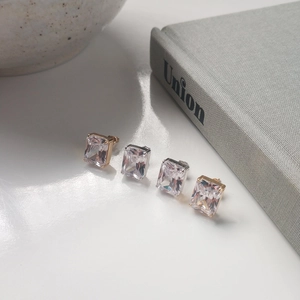 Minimalistische Zirkonia-Ohrstecker in Gold und Silber auf weißem Hintergrund