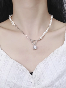 Detail of S925 silver necklace featuring pearls, heart toggle, and pear-cut zircon pendant