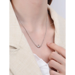 Minimalist S925 sterling silver crown necklace worn by a model in a beige suit
