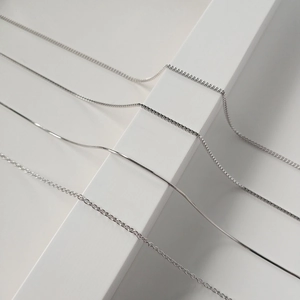 Macro shot of silver S925 sterling silver chain styles including snake and box textures