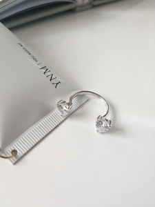 Macro shot of silver open cuff ring featuring two heart-shaped cubic zirconia stones