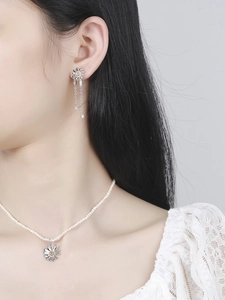 Daisy pendant pearl necklace and tassel earrings set on a model with white lace