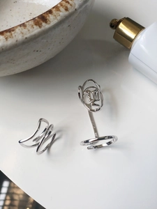Makroaufnahme von S925 Sterlingsilber Ringen mit Wellen- und Säulendesign auf weißem Tisch