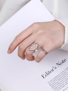 Detailed close-up of a fan-shaped silver ring featuring pearls and zircon on a hand