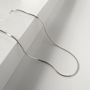Minimalist S925 sterling silver flat snake bone chain necklace displayed on a white stand