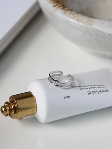 Close-up of S925 sterling silver double-layer open ring on minimalist white background