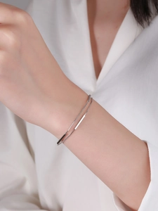 Close-up of minimalist double-layered S925 silver bracelet with polished bar accents