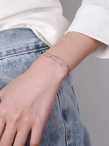 Close-up of double-layer S925 silver bracelet featuring polished minimalist metal bar charms