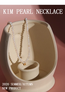 Chic S925 silver pearl necklace with gold bead pendant on artistic ceramic display
