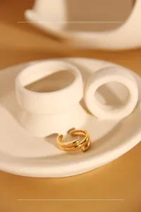 Detail of minimalist double-layered gold plated silver ring on a ceramic tray