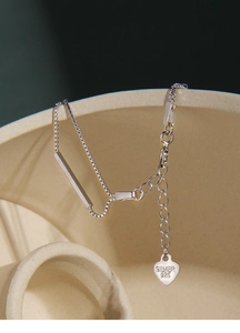 Detailed close-up of S925 sterling silver box chain with a heart tag and metal bar