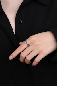 Macro detail of S925 silver ring featuring pearl flower design and black gemstone center