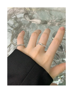 Detail view of stacked S925 sterling silver beaded and wavy rings on a hand