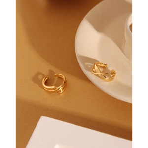 Detail of gold multilayer cross and Mobius ring set on a ceramic tray display