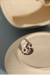 Detail of vintage silver floral ring with white pearls and antique engraved patterns