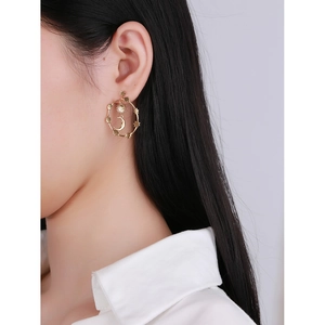 Elegant gold celestial hoop earrings with sun moon and star charms worn by model