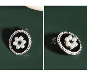 Detailed view of vintage S925 silver oval earrings with black enamel and pearl flower