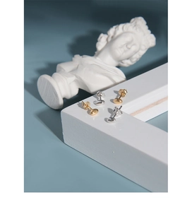Close-up of minimalist S925 sterling silver bean stud earrings in gold and silver finish