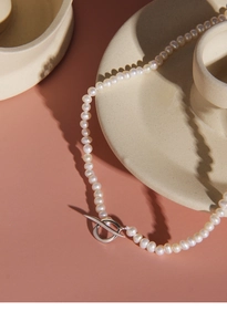 Detail view of 4-5mm freshwater pearl necklace with silver OT buckle on ceramic tray