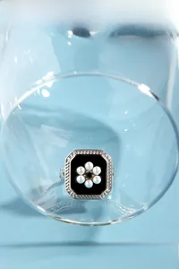 Detailed macro view of S925 silver ring featuring vintage black enamel and pearl flower