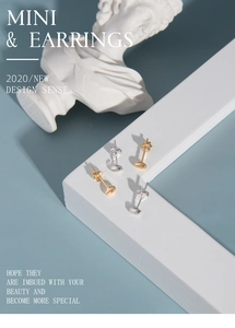 Close-up of minimalist gold and silver oval stud earrings on an artistic backdrop
