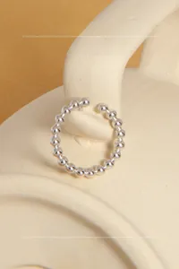 Detail view of S925 sterling silver beaded open ring on a beige ceramic background