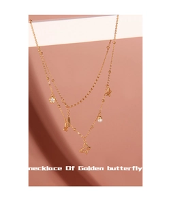 Detailansicht einer goldfarbenen Schmetterlingskette mit Perlen und funkelndem Strass