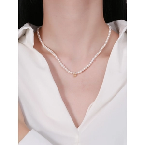 Minimalist S925 silver pearl necklace with a polished gold bead worn by a model