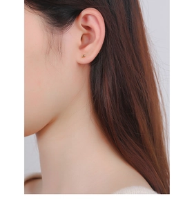 Close-up of a model wearing a gold bean stud earring made of polished S925 sterling silver
