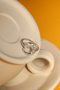 Dettaglio anello in argento S925 luna e stella con trama martellata su tazza in ceramica