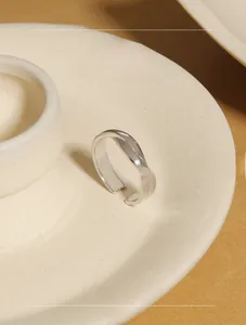 Macro detail of minimalist S925 sterling silver twisted ring on a ceramic tray