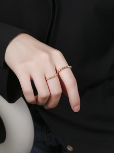 Close-up of minimalist gold twisted rope and bead stackable rings on finger