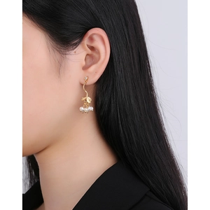 Élégantes boucles d'oreilles en argent S925 avec perles et feuilles d'or sur un mannequin