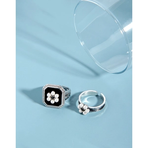Macro detail of S925 silver ring featuring black enamel and white pearl flower accents