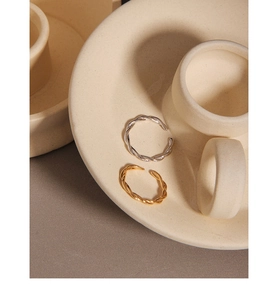 Detail of twisted rope stackable rings in gold and silver finish with open design