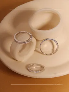 Detailed close-up of S925 sterling silver rings with cubic zirconia on ceramic stand