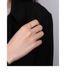 Detailed close-up of a twisted gold rope ring featuring fine spiral texture and polished finish